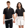 A black polo shirt with contrasting collar, displayed on a male and female model holding hands. Both models wear a belt.