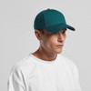 A green cap worn by a man in a white t-shirt, featuring a logo on the front.