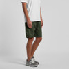 A pair of green shorts with an elastic waistband, featured on a male model standing. The shorts have a casual style.