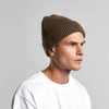 A brown ribbed beanie worn by a person, featuring a snug fit and a simple design.