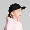 A black cap for kids, featuring a curved brim and an adjustable strap at the back, worn by a child in profile.