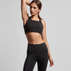 A black crop top with a square neckline, paired with high-waisted black leggings. The model is in a posed stance.