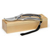 A pair of silver secateurs with a black strap, resting on a wooden box. The product features a logo.