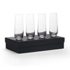 Four clear glass stemless champagne flutes arranged on a black gift box.