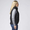 A side view of a woman wearing a black padded vest over a grey long-sleeved top, featuring a logo.