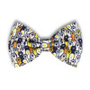 A bow tie featuring a playful pattern of colourful ghosts on a dark background. It has a branding logo.