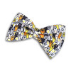 A pet bow tie featuring a pattern of colourful dogs and paw prints on a black background.