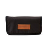 A black pouch with a tan leather label, featuring a logo, designed for travel use.