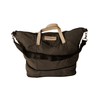 A large, dark fabric duffle bag with light beige handles and a detachable shoulder strap. It features a logo.