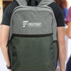 A grey and green backpack with a logo, featuring adjustable straps and a spacious front pocket.