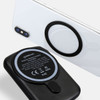 A black wireless charging power bank with a circular magnetic attachment and a smartphone in the background.