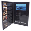 A promotional product featuring a black folder with a LCD screen displaying a video, showcasing a car with an urban backdrop.