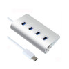 A silver USB hub with four ports and a connected white cable. It features a sleek, modern design.