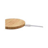A bamboo wireless charger in a circular shape with a white charging cable attached.