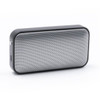 A compact black and silver wireless speaker with a mesh front design and a side port. It features a logo on the surface.