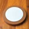 A cork wireless charger featuring a sleek, round design with a white charging pad in the center.