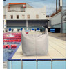 A grey cooler bag sits on a tiled surface near a pool, featuring a carry handle and a branded logo.