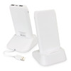 A white wireless charging station with two phone stands and a USB cable. It has a logo on the back.