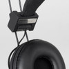 A close-up of black Opus Bluetooth headphones, featuring a padded ear cup and adjustable headband with a logo.