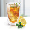 A double wall glass filled with iced tea, garnished with mint leaves, next to a slice of lemon. Features a logo.