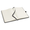 An open Petros Stone Paper Notebook with lined pages and a black cover, featuring a ribbon bookmark.