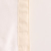 A close-up of a cream-coloured reusable linen bread bag with a textured edge and faint seam detailing.