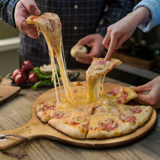 A wooden serving board with a cheese pizza, featuring gooey cheese stretching as slices are lifted.