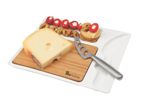 A cheese board with a wooden base, a cheese wedge, a stainless steel knife, and assorted snacks in a white tray.