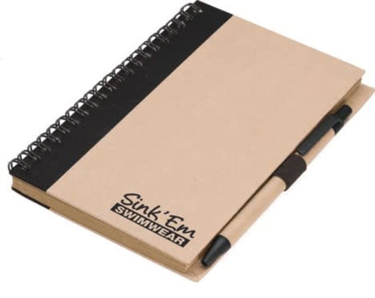 A brown notepad with a black cover and a matching pen, featuring a branding logo on the front.