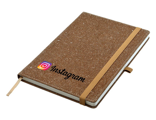 A brown A5 notebook with a textured cover and elastic band, featuring a logo on the front.