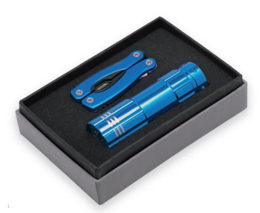 A blue flashlight and multi-tool are displayed in a black gift box with a foam insert. The box has a simple design and contains a logo.