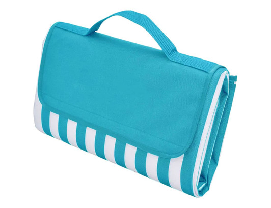 A picnic rug in aqua blue with a striped pattern, featuring a foldable design and a carrying handle.