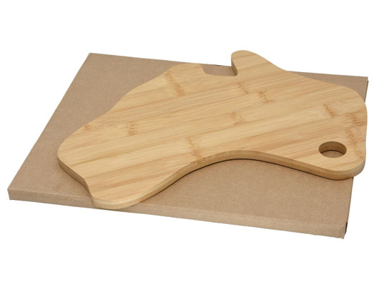 A bamboo cheese board shaped like Australia, resting on a brown cardboard base.
