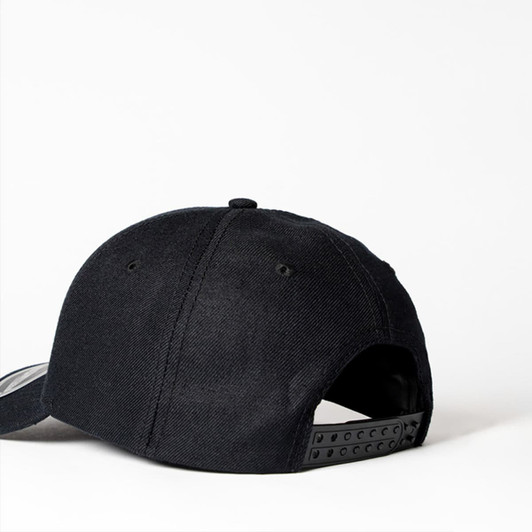 A black snapback cap featuring a six-panel design and an adjustable strap at the back. It has a logo on the side.