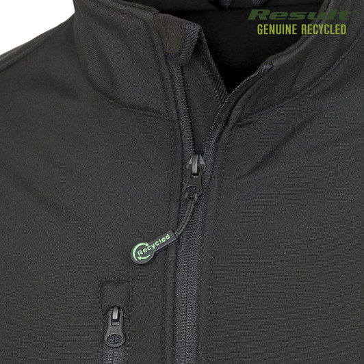 A black softshell jacket featuring a zip closure and a zippered pocket, with a branding logo.