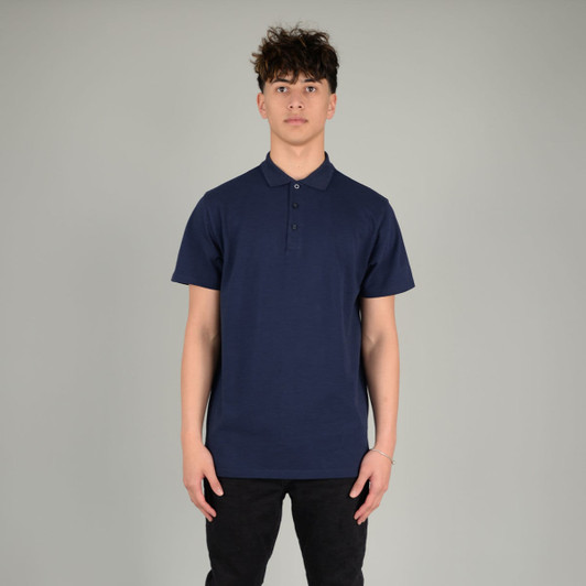 A navy blue polo shirt features a collar, buttons, and has a logo. It is modelled by a young man.