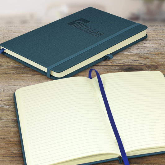 A dark blue notebook with a textured cover, featuring a logo, opened to lined pages on a wooden surface.