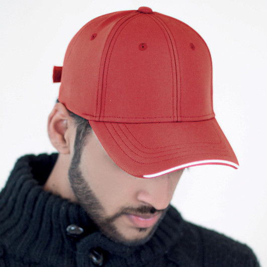 A red cap with a curved brim, featuring a structured front and a branding logo on the side.