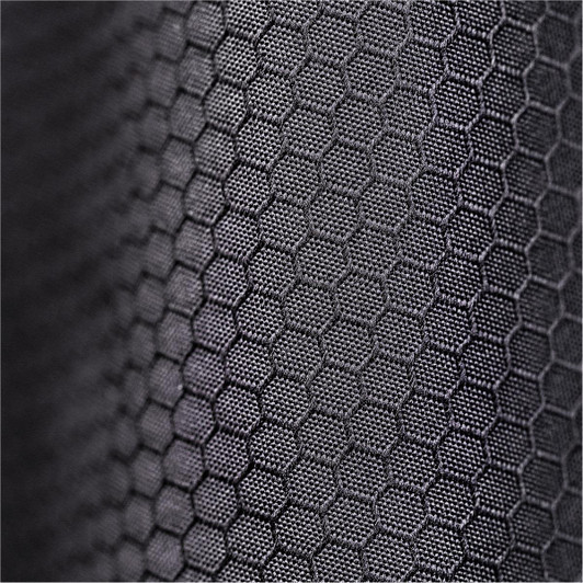 A close-up of a textured black fabric featuring a hexagonal pattern. The fabric appears durable and supportive.