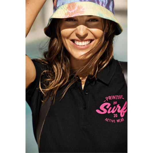 A woman wearing a black cotton polo shirt with a logo, paired with a colourful bucket hat.
