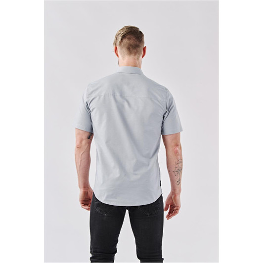 A light blue short-sleeved button-up shirt viewed from the back, featuring visible stitching and a logo label.