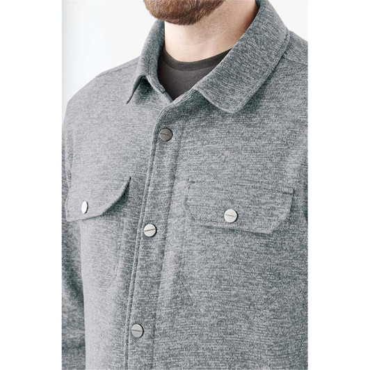 A grey unisex fleece shacket featuring a collar, two chest pockets, and snap buttons. It has a logo on the fabric.