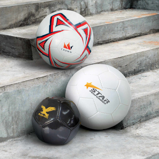 Three soccer balls in white, one with red and blue accents, one with a black design, and the other featuring branding.