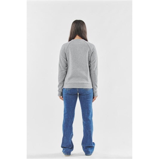 A back view of a woman wearing a grey Henley shirt with flared blue jeans. The shirt has a logo on it.
