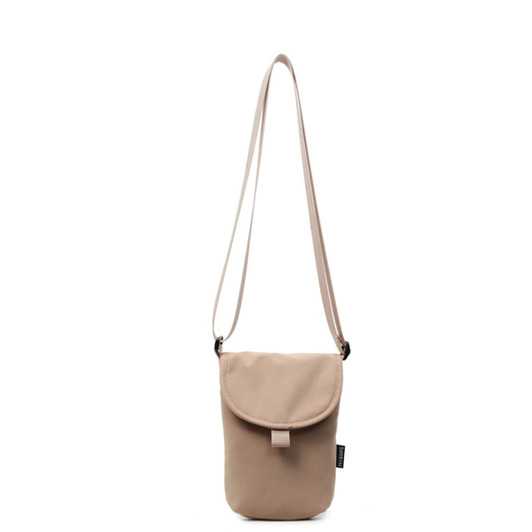 A small size canvas shoulder bag in a beige colour with a flap closure and an adjustable strap. It has a logo.