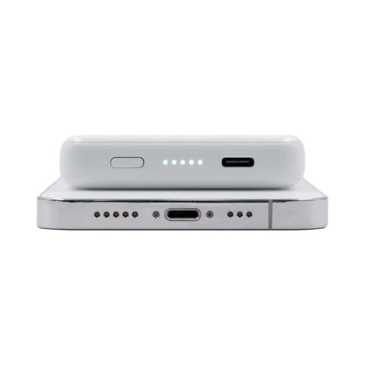 A white magnetic wireless power bank with LED indicator lights and USB-C ports on a silver surface.