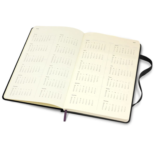 An open Moleskine 2026 weekly planner, featuring blank pages and a black cover with purple ribbon bookmark.