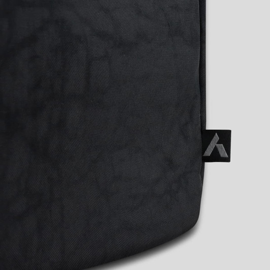 A black duffle bag featuring a textured surface and a logo on the side.