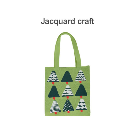 A green knitted tote bag featuring various patterned trees in shades of green and white, with a red accent.