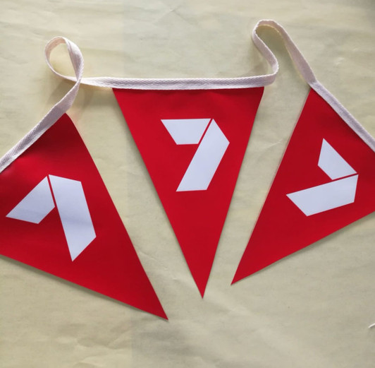 Red polyester bunting featuring triangular flags with white shapes, suspended by a white ribbon.
